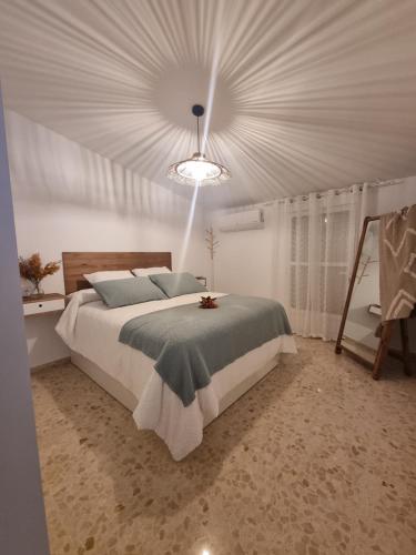 a bedroom with a large bed with a ceiling at Ático con encanto in Baena