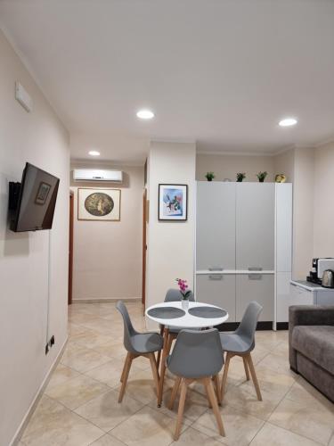 salon ze stołem, krzesłami i kanapą w obiekcie Loft Magna Grecia Reggio Calabria Centro Storico a 3 minuti a piedi dal mare w mieście Reggio di Calabria
