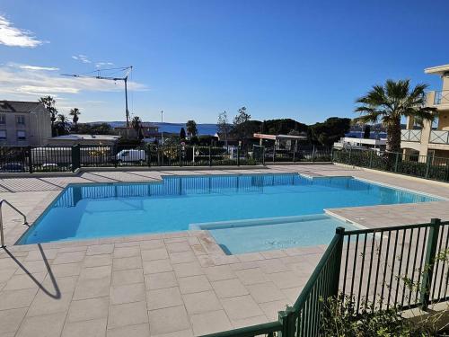 une grande piscine bleue à côté d'un immeuble dans l'établissement T2 standing, piscine, clim, proche plage, parking, animaux OK - FR-1-768-47, aux Issambres