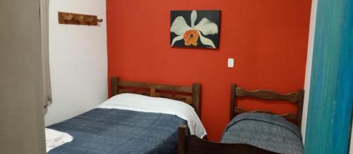 um quarto com 2 camas e uma parede vermelha em casas temporada em Tiradentes do mazinho em Tiradentes