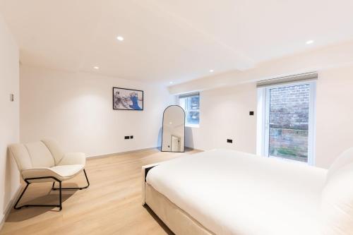 a bedroom with a bed and a chair and a mirror at The Maida Vale in London