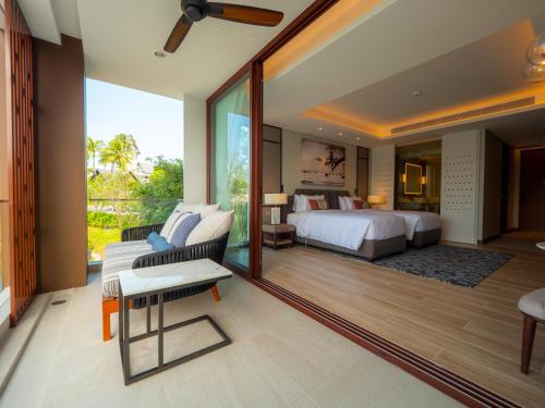 um quarto com uma cama king-size e uma varanda em Luxury apartments in the Laguna near the lake em Praia de Bang Tao