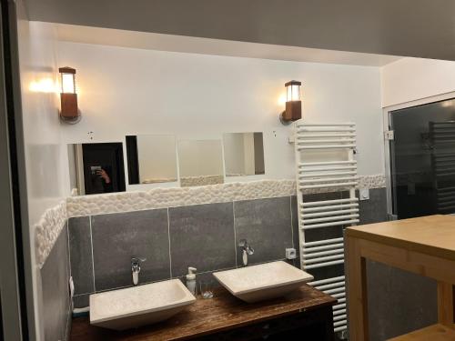 une salle de bain avec deux lavabos et un miroir dans l'établissement Loft design & familial parc des Buttes Chaumont, à Paris