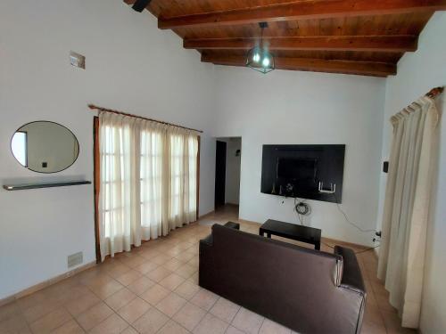 ein Wohnzimmer mit einem Sofa und einem Flachbild-TV in der Unterkunft Rincon Sanmartiniano in Mendoza