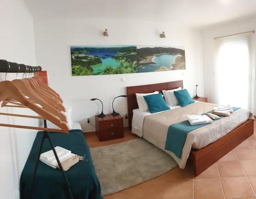 A Caminho da Ilha في بونتا ديلغادا: غرفة نوم بسرير ودهان على الحائط