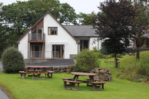 two picnic tables in front of a house at Ambleside in Tobermory