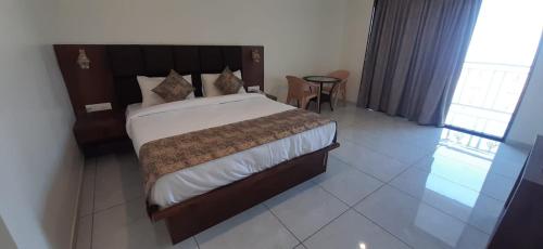 1 dormitorio con 1 cama grande y 1 mesa en Hotel Brilliant Panchgani en Pānchgani