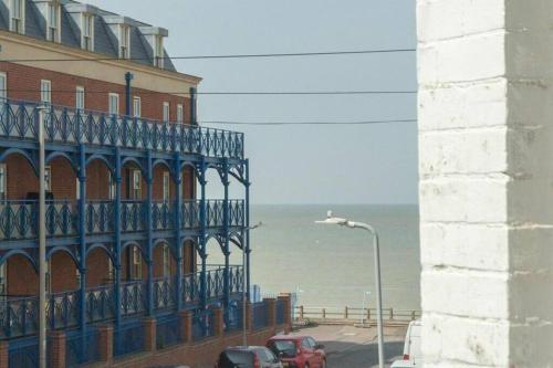 a building with a balcony next to the ocean at The Little Place By The Sea in Kent