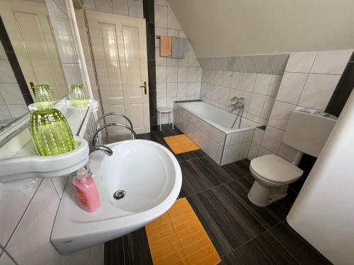 ein Badezimmer mit einem Waschbecken, einer Badewanne und einem WC in der Unterkunft Villa Werndl in Millstatt