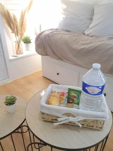 una mesa con una botella de agua junto a la cama en Studio Coquet - Comme à la maison - Loïc Nantes, en Sautron