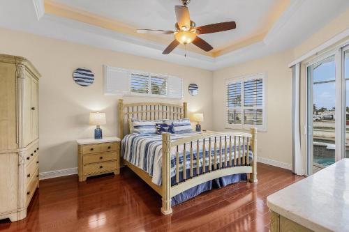 a bedroom with a bed and a ceiling fan at Luxury Waterfront Direct Gulf access - Walk to Beach & Bikes - Villa Coral Mist - Cape Coral in Cape Coral