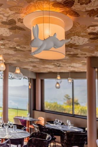 a dining room with tables and a whale hanging from the ceiling at Best Western Aquakub in Aix-les-Bains