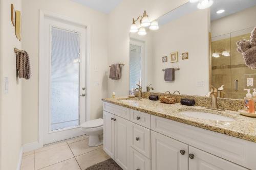 a bathroom with a sink and a toilet and a mirror at Luxury Waterfront Direct Gulf access - Walk to Beach & Bikes - Villa Coral Mist - Cape Coral in Cape Coral