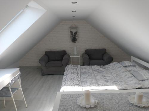 a bedroom with a bed and couches in a attic at Domek dwupoziomowy 