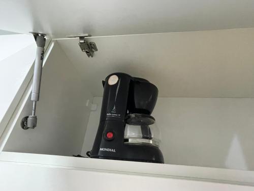 a black coffee maker in a corner of a wall at Studio aeroporto Congonhas in Sao Paulo
