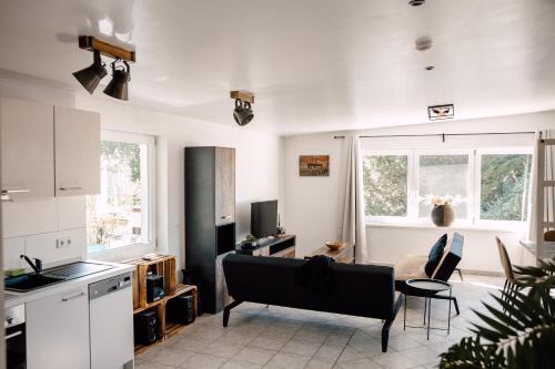 een woonkamer met een bank en een keuken bij Apartment in Seenähe in Berlijn