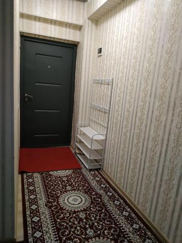 een hal met een zwarte deur en een rood tapijt bij Yunusobod kvartira. Medical center 
