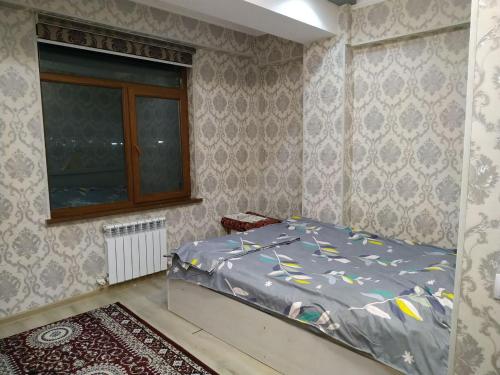 een kleine slaapkamer met een bed en een raam bij Yunusobod kvartira. Medical center 