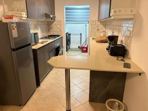 a kitchen with a counter top and a refrigerator at MAURISIA APARTMENT Trou Aux Biches in Pamplemousses Village