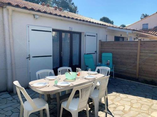 d'une table blanche avec des chaises blanches, d'une table blanche et d'une chaise longue. dans l'établissement La Palmyre - PETITE VILLA MITOYENNE -PISCINE COLLECTIVE- PROCHE CENTRE, aux Mathes