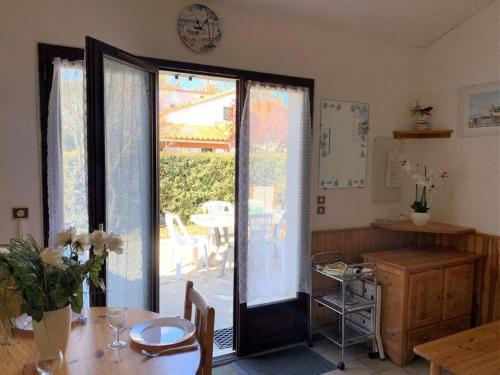 d'une salle à manger avec une table et une porte coulissante en verre. dans l'établissement La Palmyre - PETITE VILLA MITOYENNE -PISCINE COLLECTIVE- PROCHE CENTRE, aux Mathes