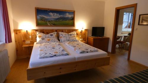 a bedroom with a large bed with white sheets and pillows at Sonnhof in Sankt Gilgen