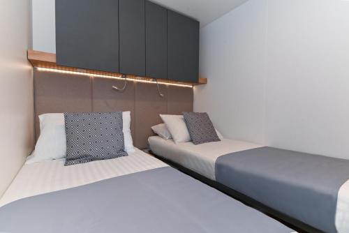 two beds in a small room with a cabinet at MORENIA Park Villas in Podaca