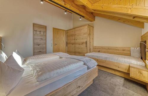 a large bedroom with two beds and wooden walls at Appart-Hotel Wildererstuben in Bodenmais