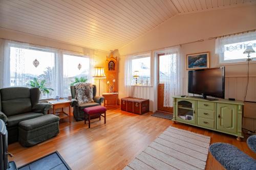 a living room with a couch and a tv at Lofothuset - koselig hus på Fredvang in Hovdan