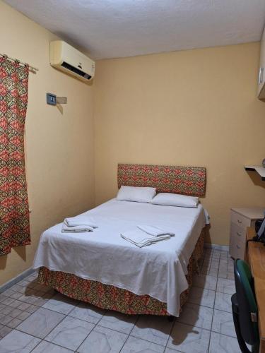 Un dormitorio con una cama con dos servilletas. en Casa com ar condicionado, en Lauro de Freitas