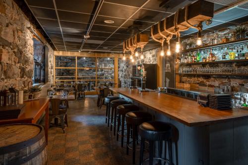 um bar com bancadas de madeira e bancos de bar em Auberge de l'Abbaye d'Oka em Oka