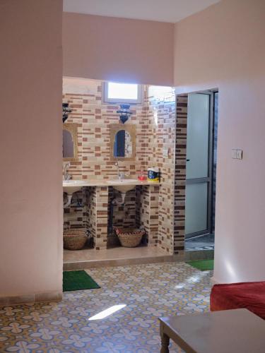 a bathroom with a stone fireplace in a room at Panorama chez Hamid in Rissani