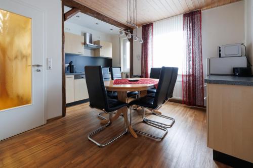 a dining room with a table and black chairs at Winneburger Hof in Ernst