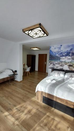 una camera da letto con un letto e un dipinto sul muro di CIABAS Apartamenty a Białka