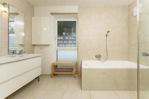 ein Bad mit einer Badewanne, einem Waschbecken und einer Dusche in der Unterkunft Appartement Göbel by Schladming Appartements in Haus im Ennstal