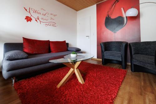 a living room with a couch and a red rug at Winneburger Hof in Ernst