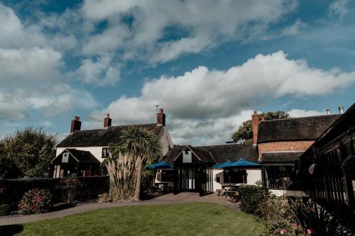 a house with a palm tree in front of it at Oak Farm Hotel in Cannock
