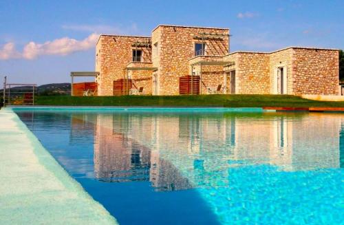 a building is reflected in a pool of water at Stone Bay Houses in Messinia Kalamaki Beach Area in Chrani