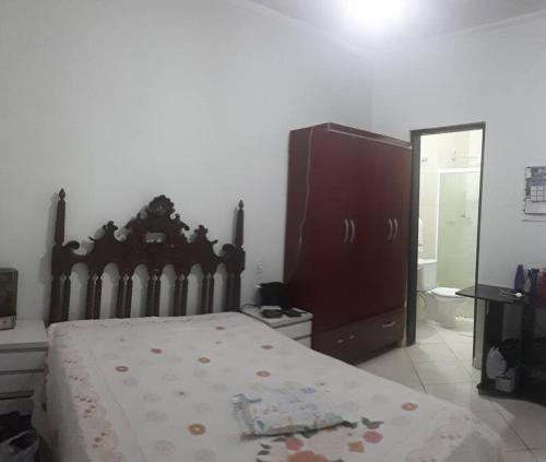 a bedroom with a bed and a dresser and a mirror at Casa confortável com 4 suítes para até 20 pessoas. in Itanhaém