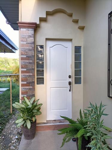 a front door of a house with plants at Regina's Vacation House in Tayud