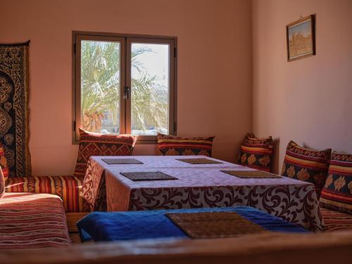 a room with a table and chairs and a window at Panorama chez Hamid in Rissani