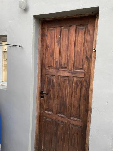 eine Holztür an der Seite eines Gebäudes in der Unterkunft Monoambiente para 3 in Santa Teresita