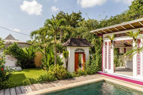 ein Haus mit einem Pool und einem Garten in der Unterkunft Gorgeous Colorful & Tropical Villa Canggu - VYG in Canggu