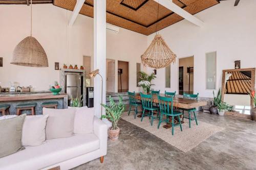 ein Wohnzimmer mit einem weißen Sofa, einem Tisch und Stühlen in der Unterkunft Gorgeous Colorful & Tropical Villa Canggu - VYG in Canggu
