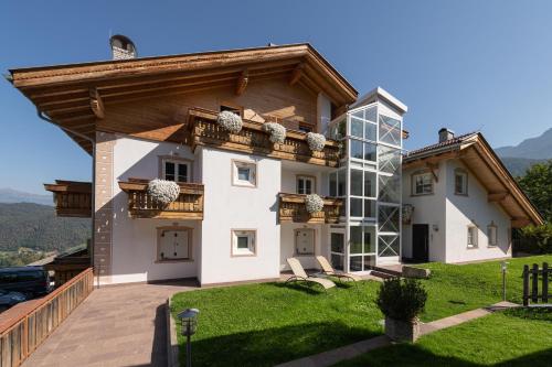 a large house with a balcony on top of a yard at Cristallo B&B in Castelrotto