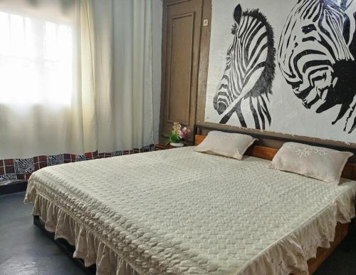a bedroom with a bed with two zebras on the wall at Akagera guide's House in Kabarondo