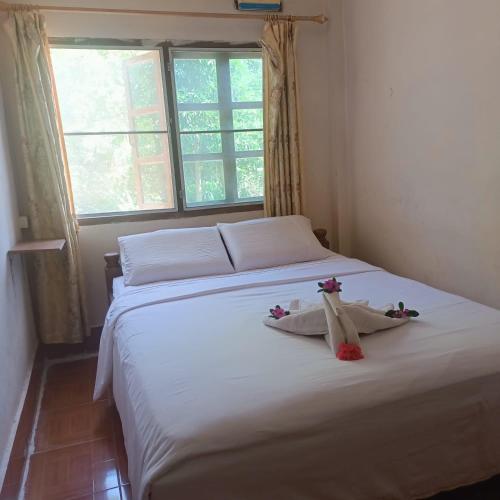 una camera da letto con un letto con due animali di peluche sopra di Phonephithak Guesthouse a Pakbeng