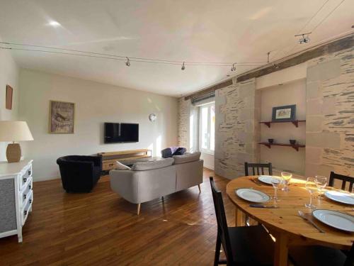 een woonkamer met een tafel en een bank bij Casa Blancheraie in Angers