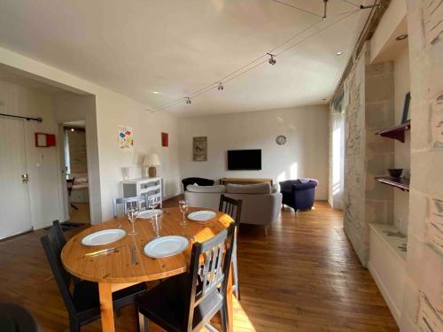 - une salle à manger et un salon avec une table en bois dans l'établissement Casa Blancheraie, à Angers
