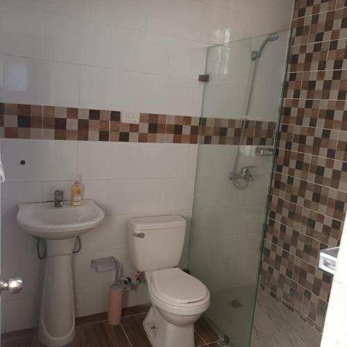 a bathroom with a toilet and a sink and a shower at Apto. a 3 minutos de la playa. Aire FULL in Azua de Compostela